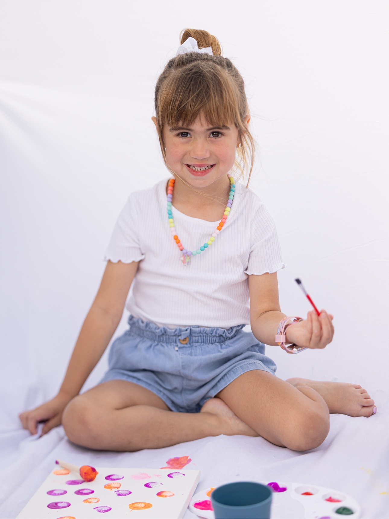 Niña sentada con su pincel en su Paint Day Party